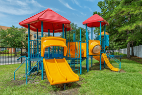 Jacksonville apartment for rent - a playground with a colorful swing set and slides