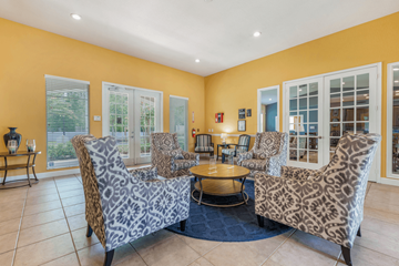Jacksonville apartment for rent - A living room with leopard print chairs and a blue rug.
