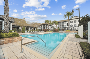 Orlando apartment for rent - A swimming pool surrounded by a brick wall and a tiled walkway.
