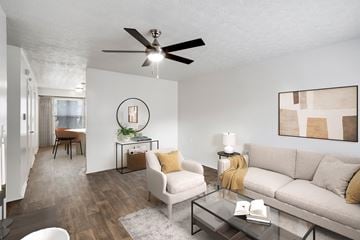 Jacksonville apartment for rent - A living room with a couch, chair, and a table with a book on it.