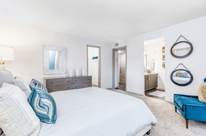 Charlotte apartment for rent - A bedroom with a large bed and a blue couch at Madison Southpark Apartment Homes, Charlotte