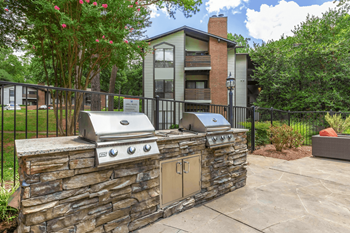 A stone wall with a grill on top of it.
