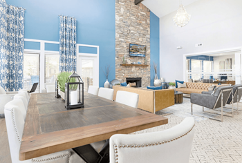 A dining room with a wooden table and white chairs.