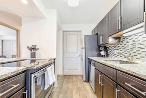 Charlotte apartment for rent - A kitchen with dark wood cabinets and granite countertops at Madison Southpark Apartment Homes, Charlotte, NC