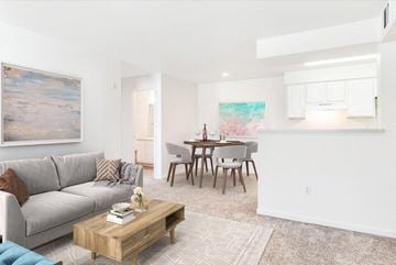 Federal Heights apartment for rent - A living room with a grey couch, a coffee table, and a painting on the wall.