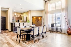 Federal Heights apartment for rent - Clubhouse Kitchen with Long Dining Table and CHairs Next to Tall Windows