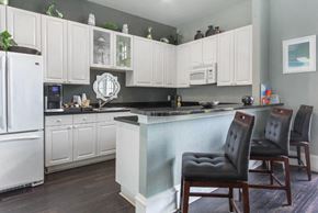 Riverview apartment for rent - Decorated Clubhouse Kitchen with White Cabinets White Appliances with Black Counters and Brown Bar Stools