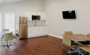 Marietta apartment for rent - A kitchen with a refrigerator, microwave, and a dining table with chairs.