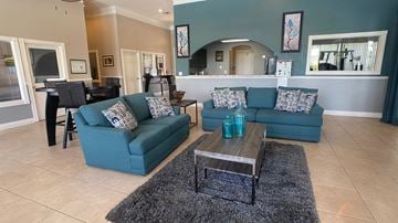 Orlando apartment for rent - A living room with a blue couch and a coffee table.