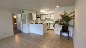 Orlando apartment for rent - Kitchen view with ceramic tile flooring, breakfast bar, and white appliances.