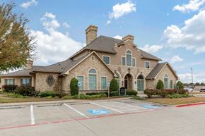 Dallas apartment for rent - Leasing Clubhouse Exterior with cloudy skies, parking spaces, and green trees