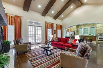 Dallas apartment for rent - A living room with a red couch and a coffee table.