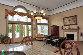 Greenville apartment for rent - Resident Lounge Area with tables , sofa , chairs and fireplace