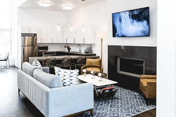 Sandy apartment for rent - A modern living room with a grey couch and a television mounted on the wall.