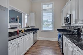 Cary apartment for rent - A kitchen with white cabinets and black countertops.