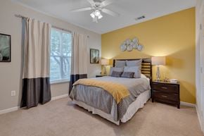 Cary apartment for rent - A bedroom with a bed, nightstand, and window.