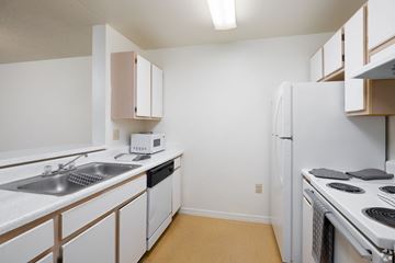 Kissimmee apartment for rent - A kitchen with white cabinets and appliances.