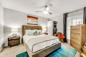 Carrollton apartment for rent - bedroom with bed, end tables and dresser by the window