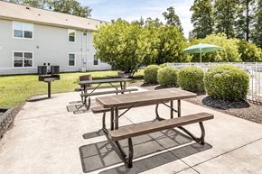 Newport News apartment for rent - two picnic tables with an umbrella and a grill