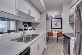 Raleigh apartment for rent - A modern kitchen with white cabinets and stainless steel appliances.