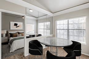 Plano apartment for rent - a bedroom with a bed and a glass table and chairs