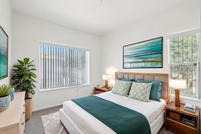 Peoria apartment for rent - A bedroom with a large bed and a painting on the wall.