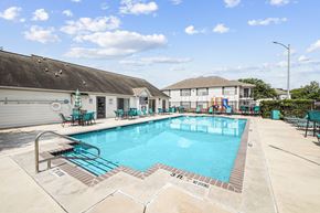 San Antonio apartment for rent - A large outdoor swimming pool with a slide and lounging chairs.