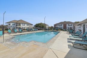San Antonio apartment for rent - A swimming pool surrounded by lounge chairs and umbrellas.