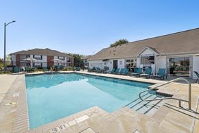 San Antonio apartment for rent - A large swimming pool with a slide and lounge chairs.