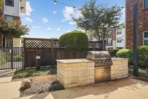 Dallas apartment for rent - A backyard with a BBQ grill and a small garden.
