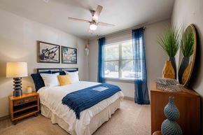 Dallas apartment for rent - A bedroom with a large bed and a ceiling fan.