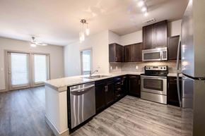 Dallas apartment for rent - A modern kitchen with dark brown cabinets and stainless steel appliances.