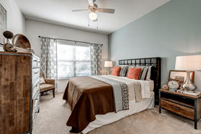Roanoke apartment for rent - A bedroom with a bed, nightstand, and a ceiling fan.
