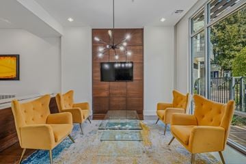 Dallas apartment for rent - A living room with yellow chairs and a flat screen TV.
