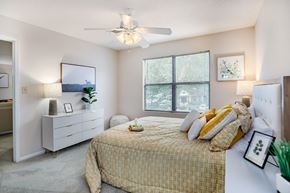 Douglasville apartment for rent - A bedroom with a bed, dresser, and window.