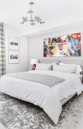 Miami apartment for rent - A bedroom with a large bed and a chandelier.