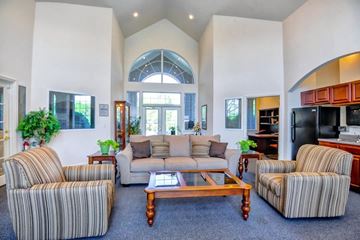 Greensboro apartment for rent - A living room with striped chairs and a wooden coffee table.