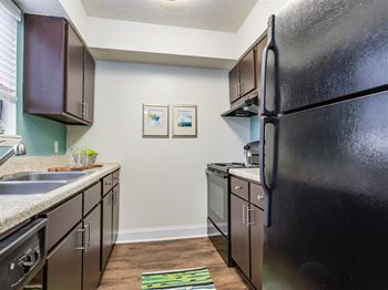 Fully equipped kitchen with brown cabinets and black appliances