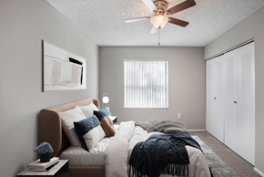 Davie apartment for rent - A bedroom with a bed covered in a blanket and pillows.
