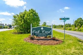 Kannapolis apartment for rent - a sign for oak creek apartments with a street sign in front of it