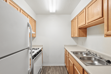 Phoenix apartment for rent - A kitchen with wooden cabinets and a white refrigerator.