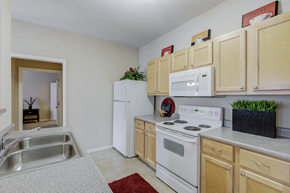 Indianapolis apartment for rent - A kitchen with white appliances and wooden cabinets.