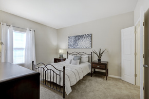 Indianapolis apartment for rent - A bedroom with a bed, nightstand, and a painting on the wall.