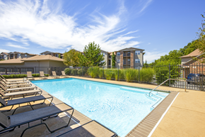 Indianapolis apartment for rent - A swimming pool surrounded by lounge chairs and a fence.