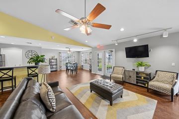Sanford apartment for rent - A living room with a brown leather couch and a ceiling fan.