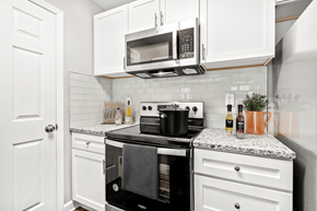 Matthews apartment for rent - A kitchen with a black stove top oven and white cabinets at Paces Pointe Apartment Homes, Matthews