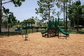 Bradenton apartment for rent - Playground jungle gym and playground slides in a bed of mulch with trees in the background