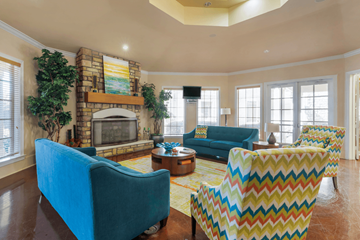 Denton townhouse for rent - A living room with a blue couch and a yellow and red chair.