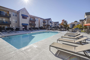 Wilmington apartment for rent - A sunny day at the pool with lounge chairs and apartment buildings in the background.