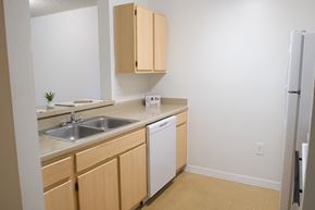 Clermont apartment for rent - A kitchen with a white dishwasher and wooden cabinets.